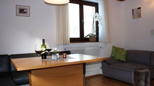Eine Aufnahme des Esstisches mit Sitzecke im Appartement 2 - "Reiterkogel" Wohnzimmer | © Haus Tannenblick