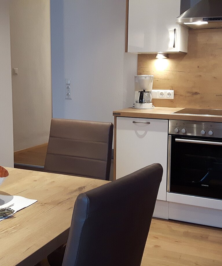 Eine Aufnahme der voll ausgestattete Wohnküche mit Esstisch im Appartement 3 - "Kohlmais" | © Haus Tannenblick